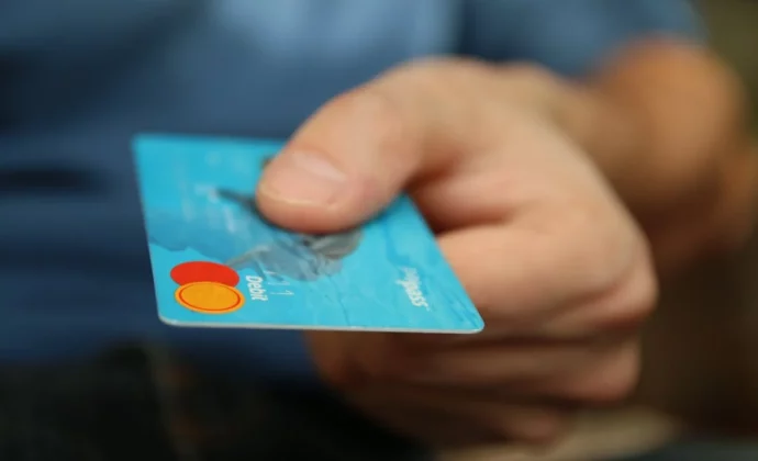 A close up of a person handing over a credit card