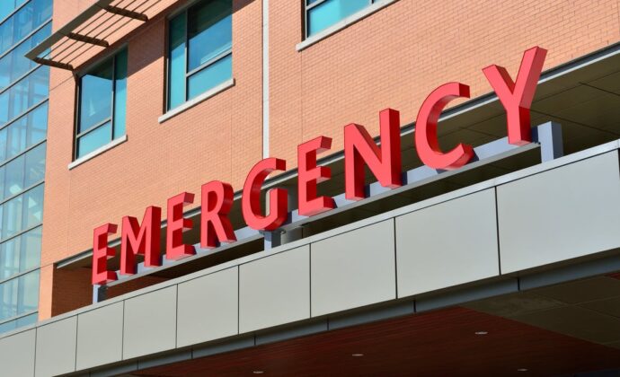 The awning sign above the entrance to a hospital reading 'Emergency'
