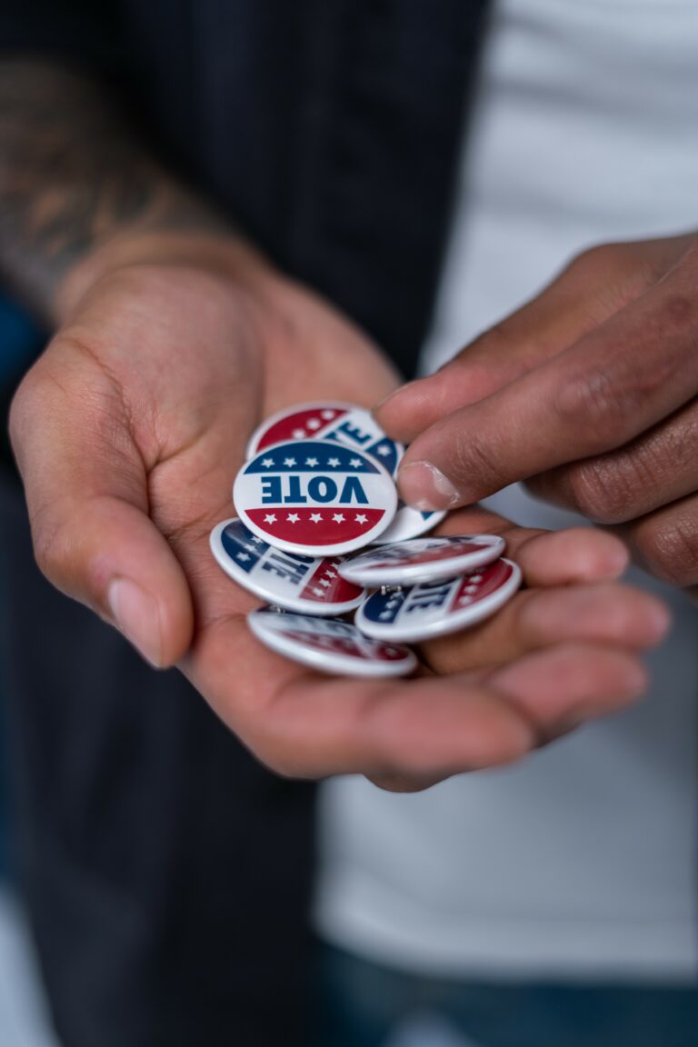 A close up of hands with "Vote" buttons in them