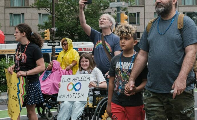 Id…Disabled and non-disabled people walking together in a parade.