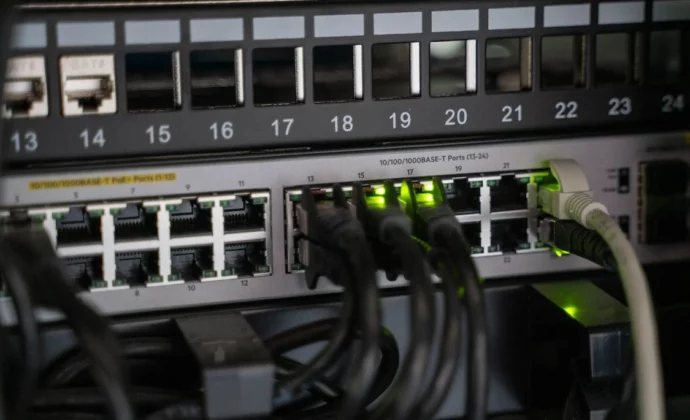 A close up of ethernet cables plugged into a network router hub