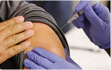 A close up of a persons' arm receiving a vaccine.