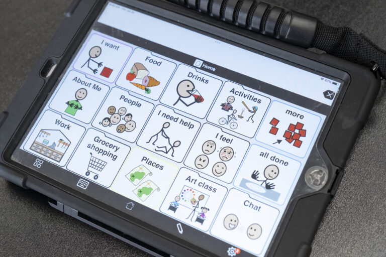 A tablet displaying AAC communication icons