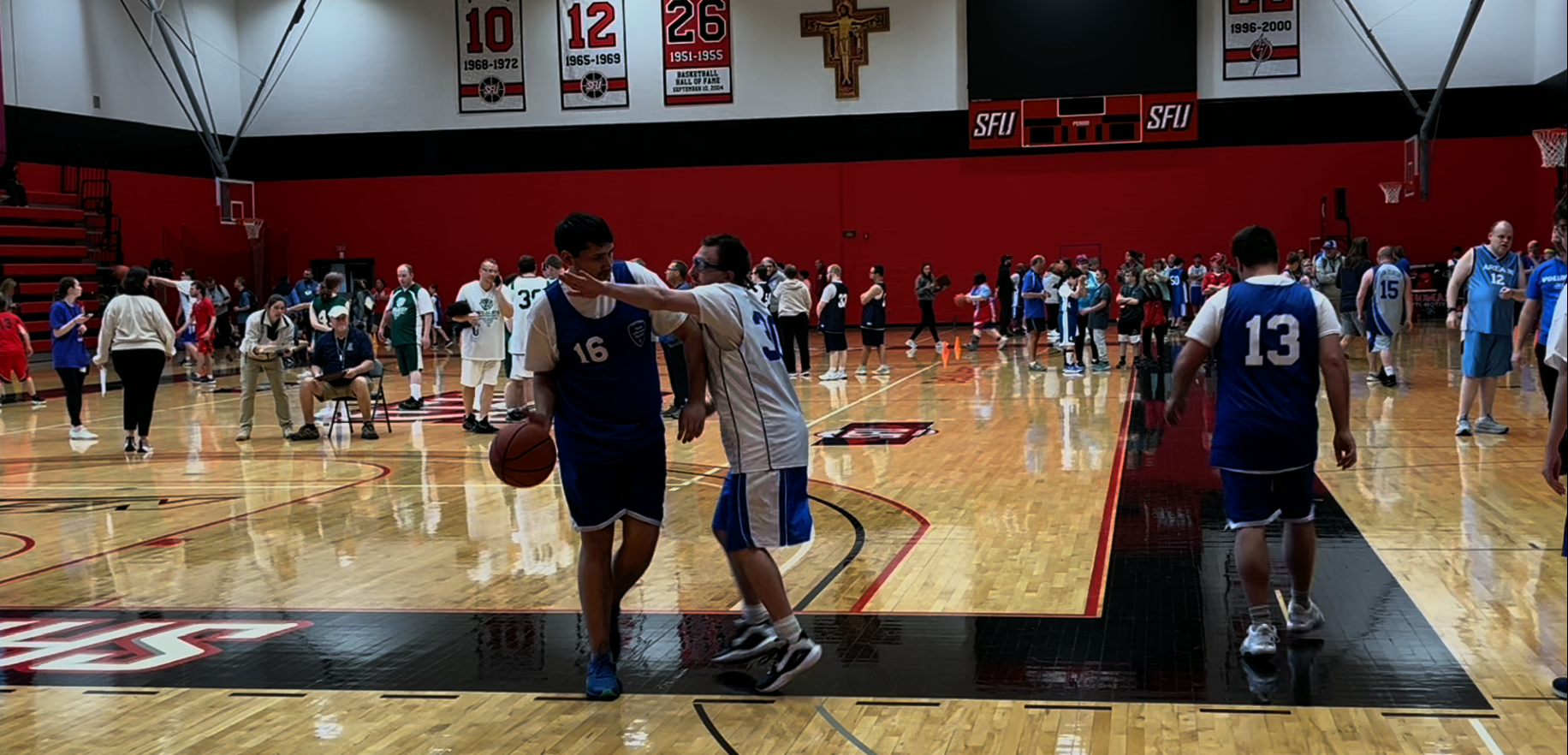 One basket ball player defends another player who is dribbling the ball