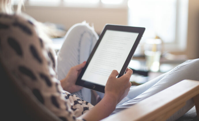 Behind the shoulder of a woman using an ipad