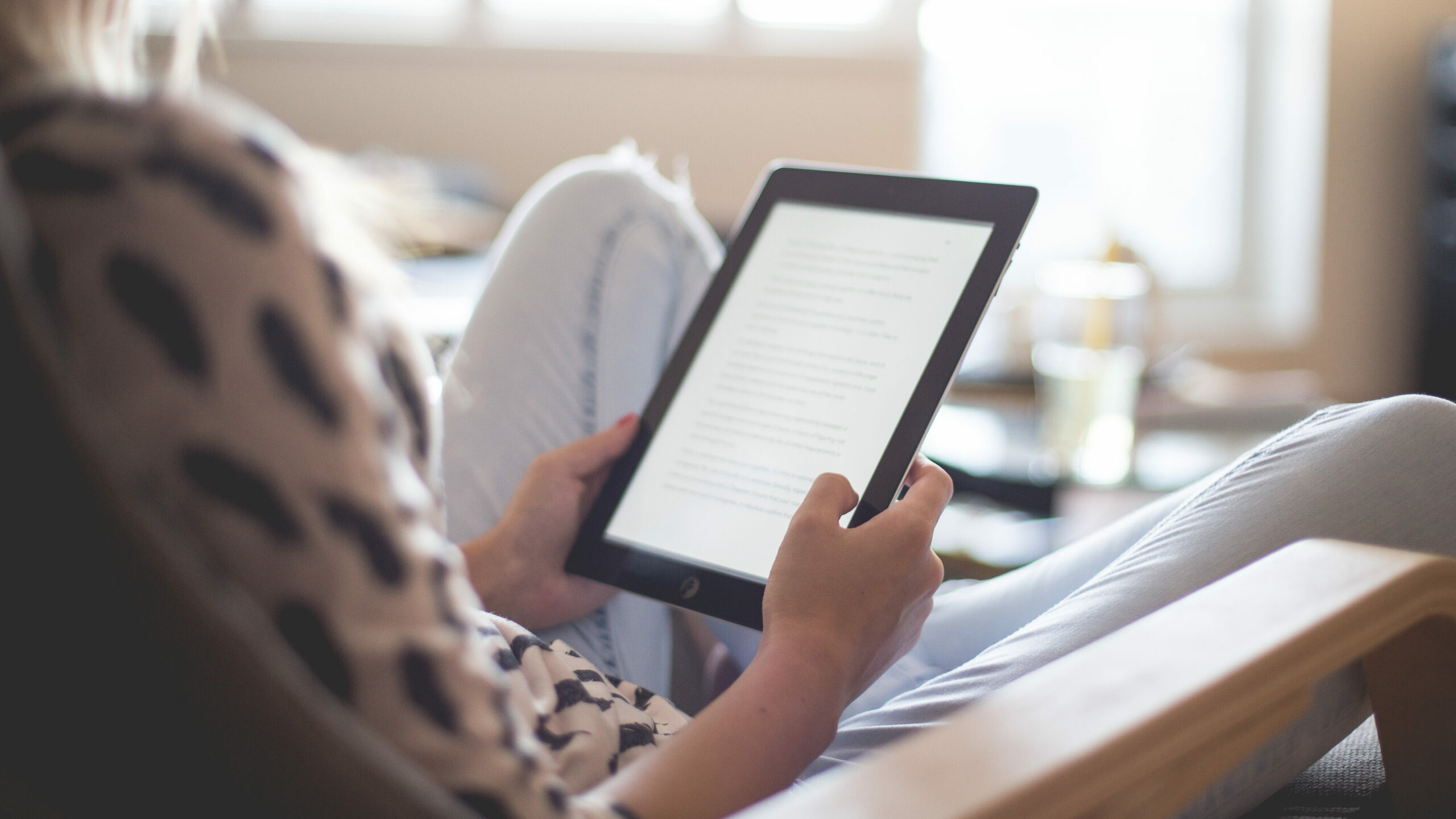 Behind the shoulder of a woman using an ipad