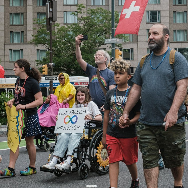 A group of people march through the streets showing their disability pride.